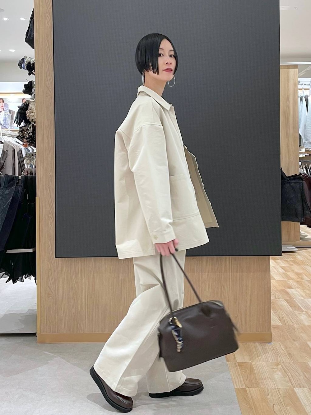 ブラウン系のローファー、ブラウン系のボストンバッグ、ベージュ系のニット/セーターを着用したレディースの春コーディネートの3枚目の写真