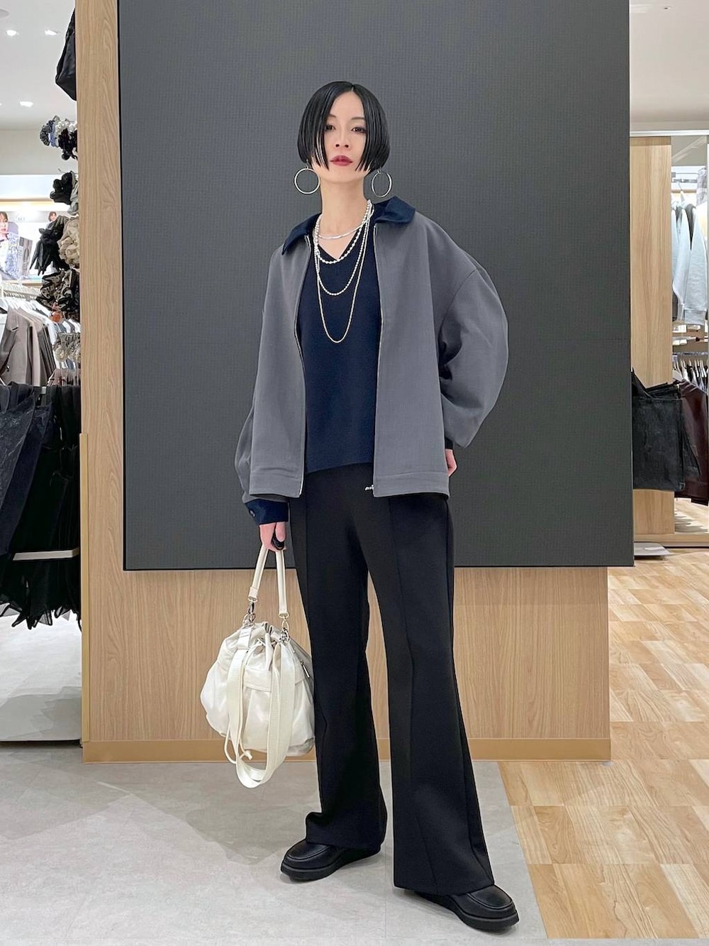 ブラック系のローファー、ホワイト系のショルダーバッグ、ブラック系のスウェットパンツを着用したレディースの春コーディネートの6枚目の写真