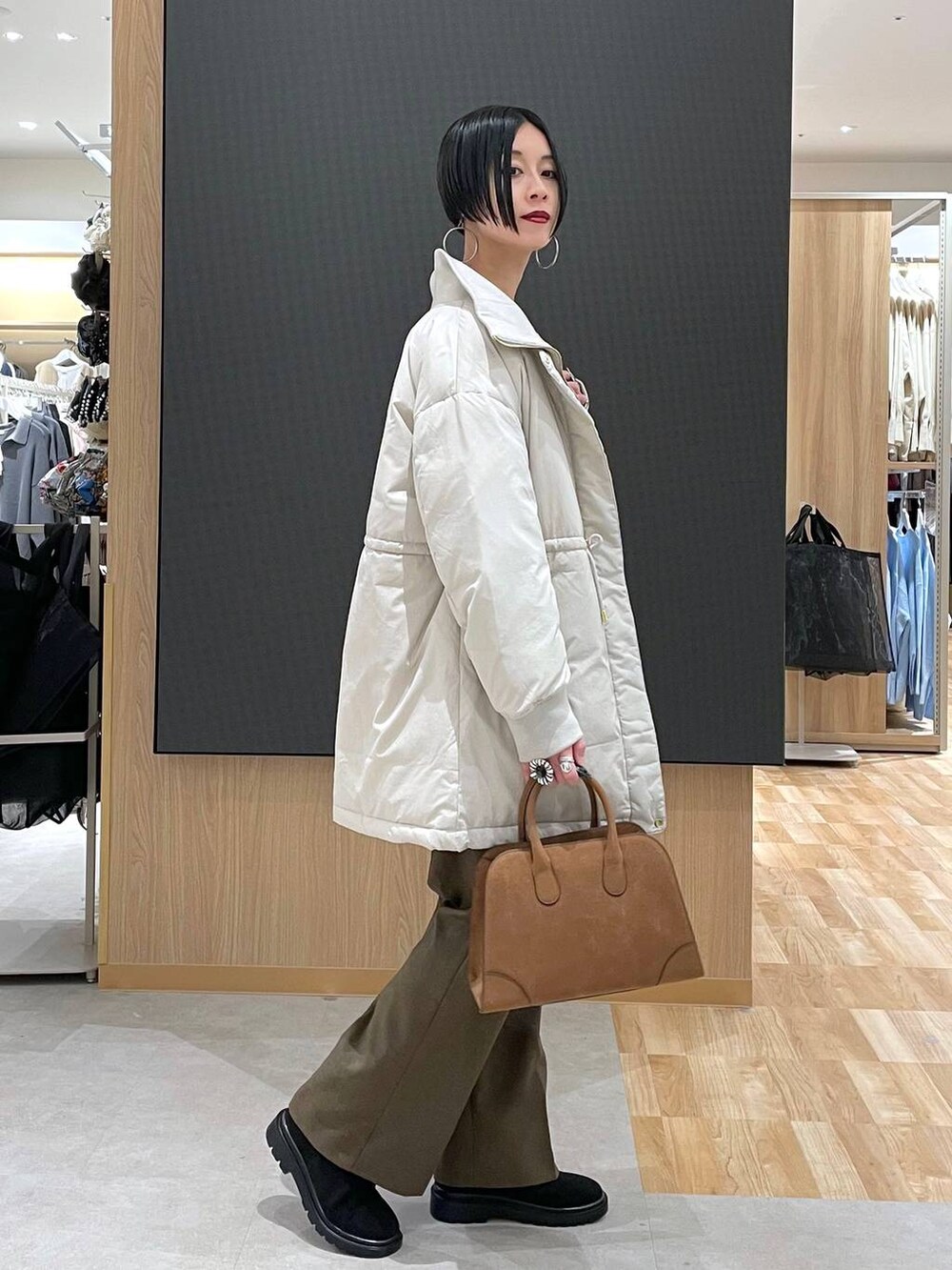 ベージュ系のダウンジャケット/コート、ブラウン系のその他パンツ、ベージュ系のショルダーバッグを着用したレディースの秋コーディネートの3枚目の写真