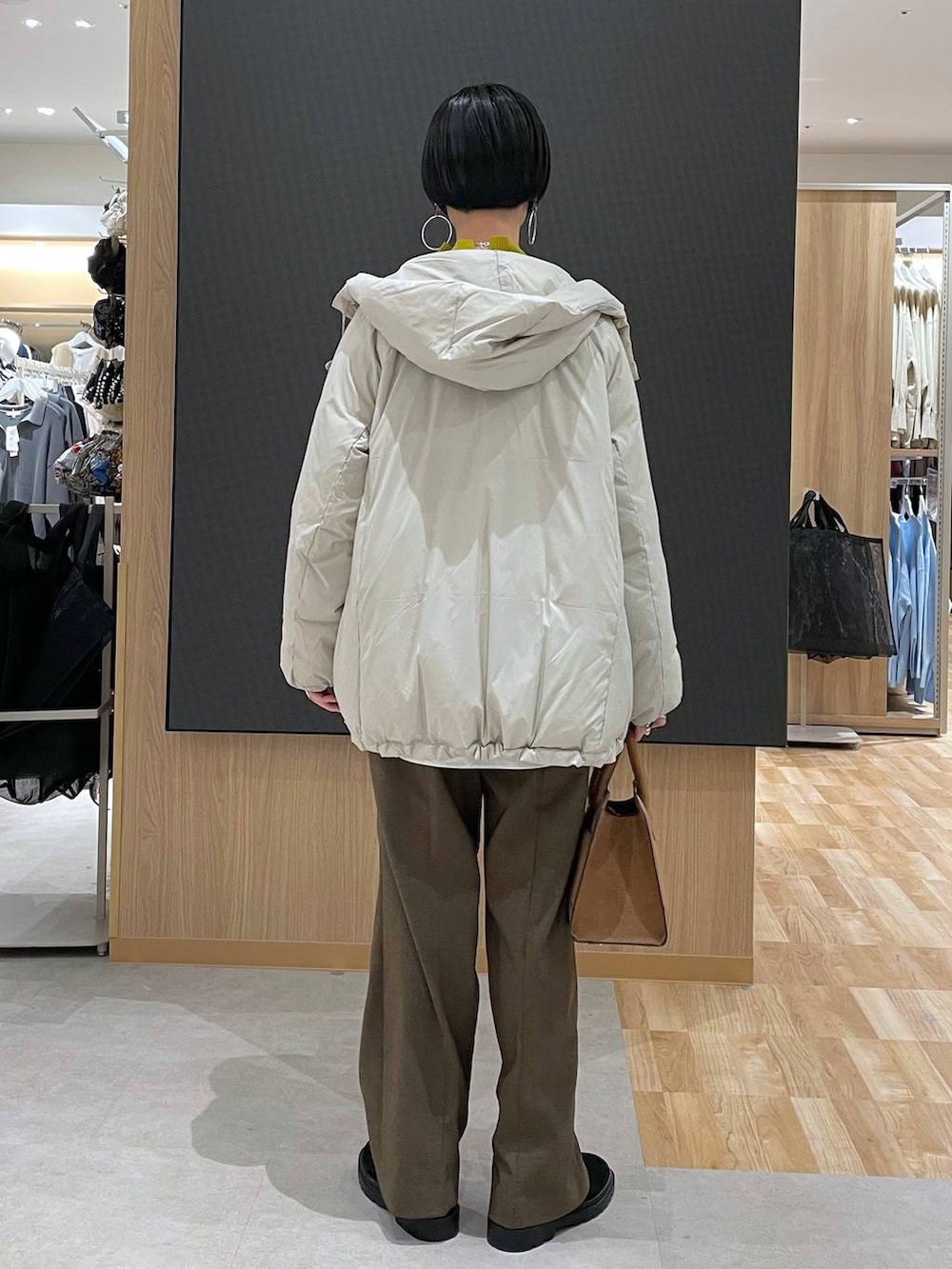 ベージュ系のダウンジャケット/コート、ブラウン系のその他パンツ、ベージュ系のショルダーバッグを着用したレディースの冬コーディネートの4枚目の写真