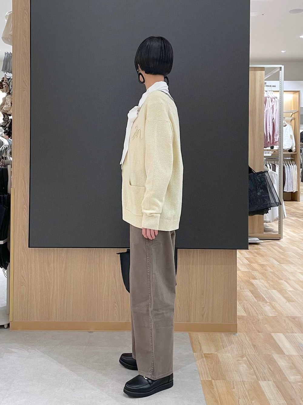 ブラック系のローファー、ブラック系のトートバッグ、ブラウン系のデニムパンツを着用したレディースの春コーディネートの5枚目の写真