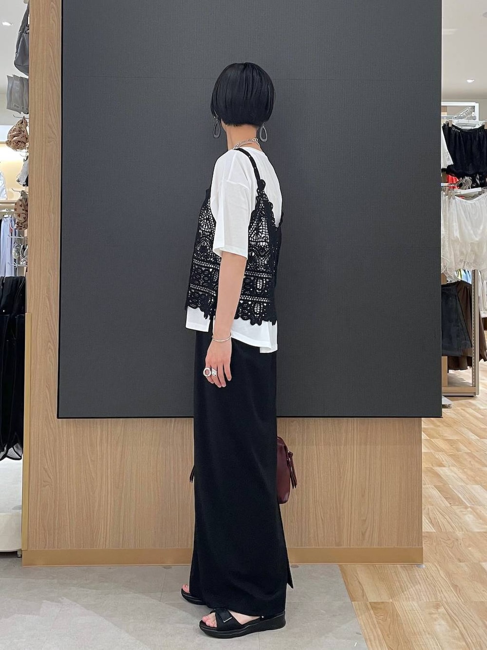 ブラック系のスカート、レッド系のボストンバッグ、ホワイト系のTシャツ/カットソーを着用したレディースの夏コーディネートの5枚目の写真