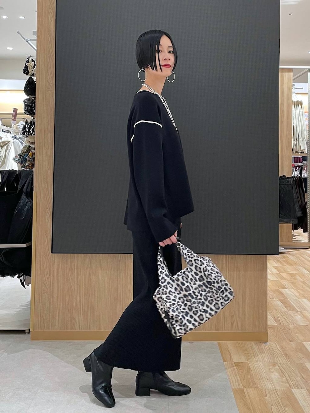 その他のトートバッグ、ブラック系のワンピース、ブラック系のブーツを着用したレディースの冬コーディネートの3枚目の写真