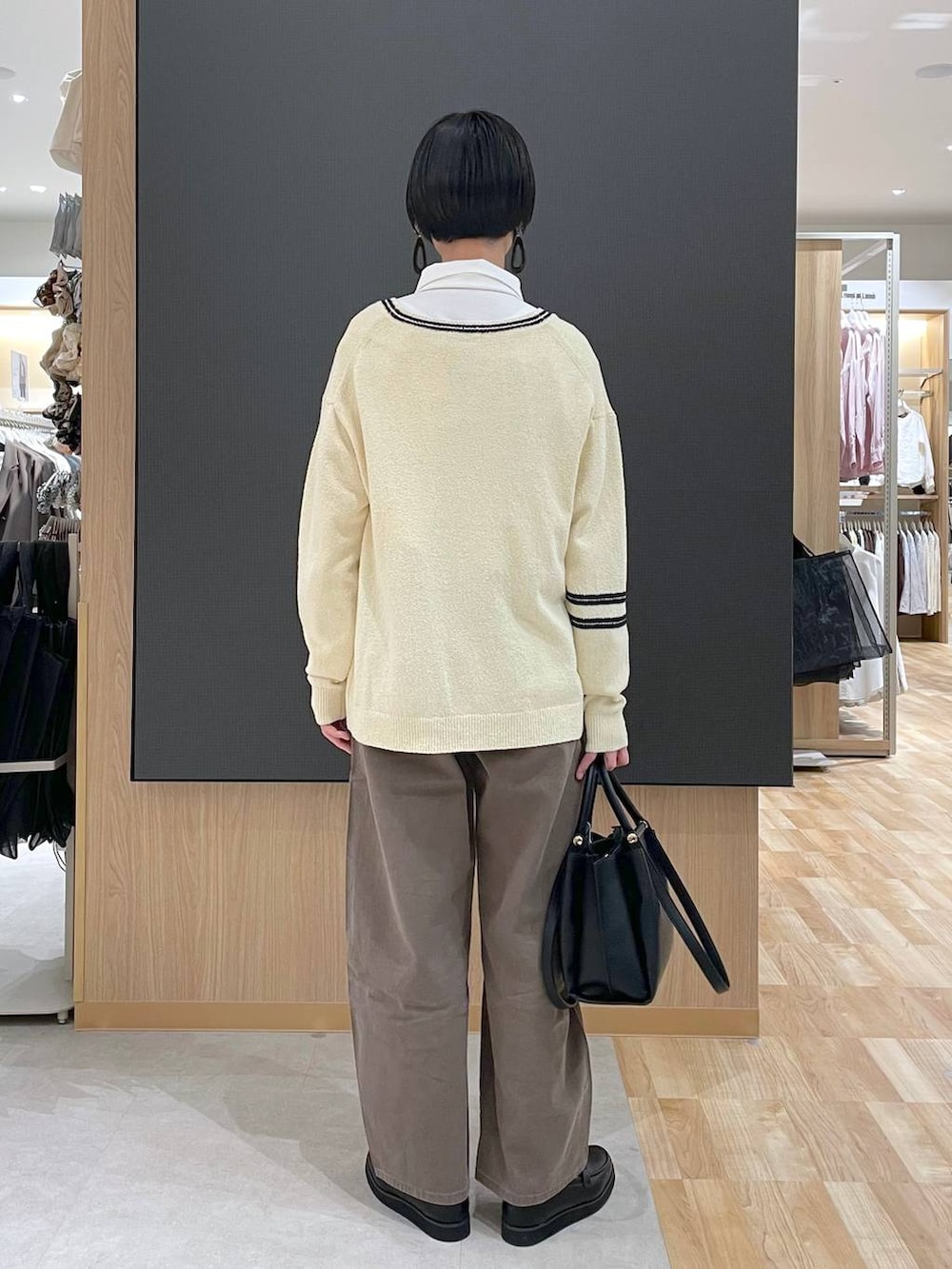 ブラック系のローファー、ブラック系のトートバッグ、ブラウン系のデニムパンツを着用したレディースの春コーディネートの4枚目の写真