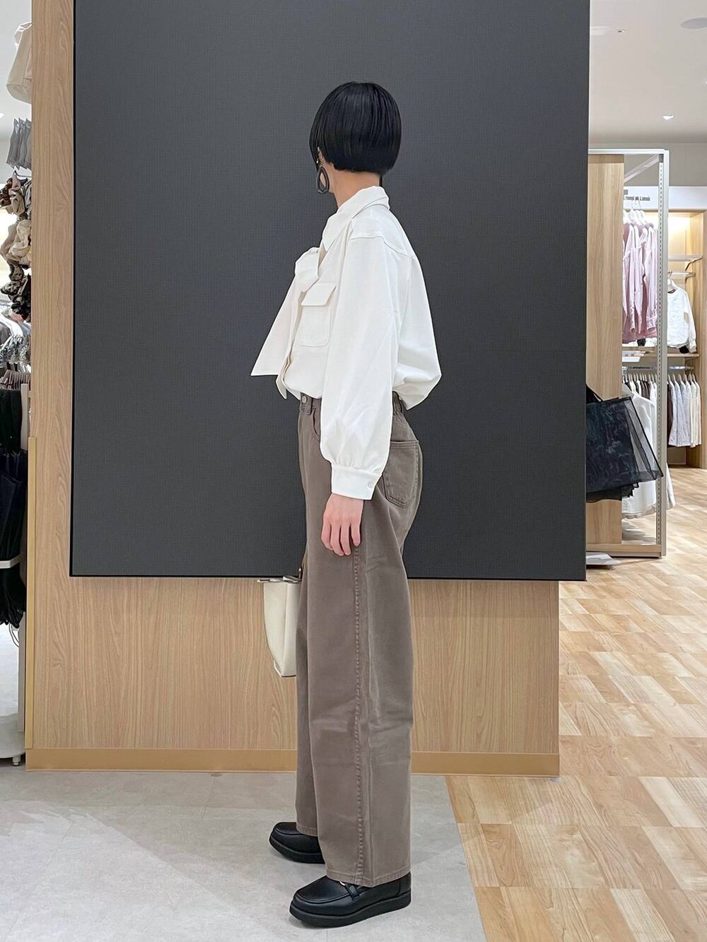 ブラック系のローファー、ブラック系のトートバッグ、ブラウン系のデニムパンツを着用したレディースの春コーディネートの10枚目の写真