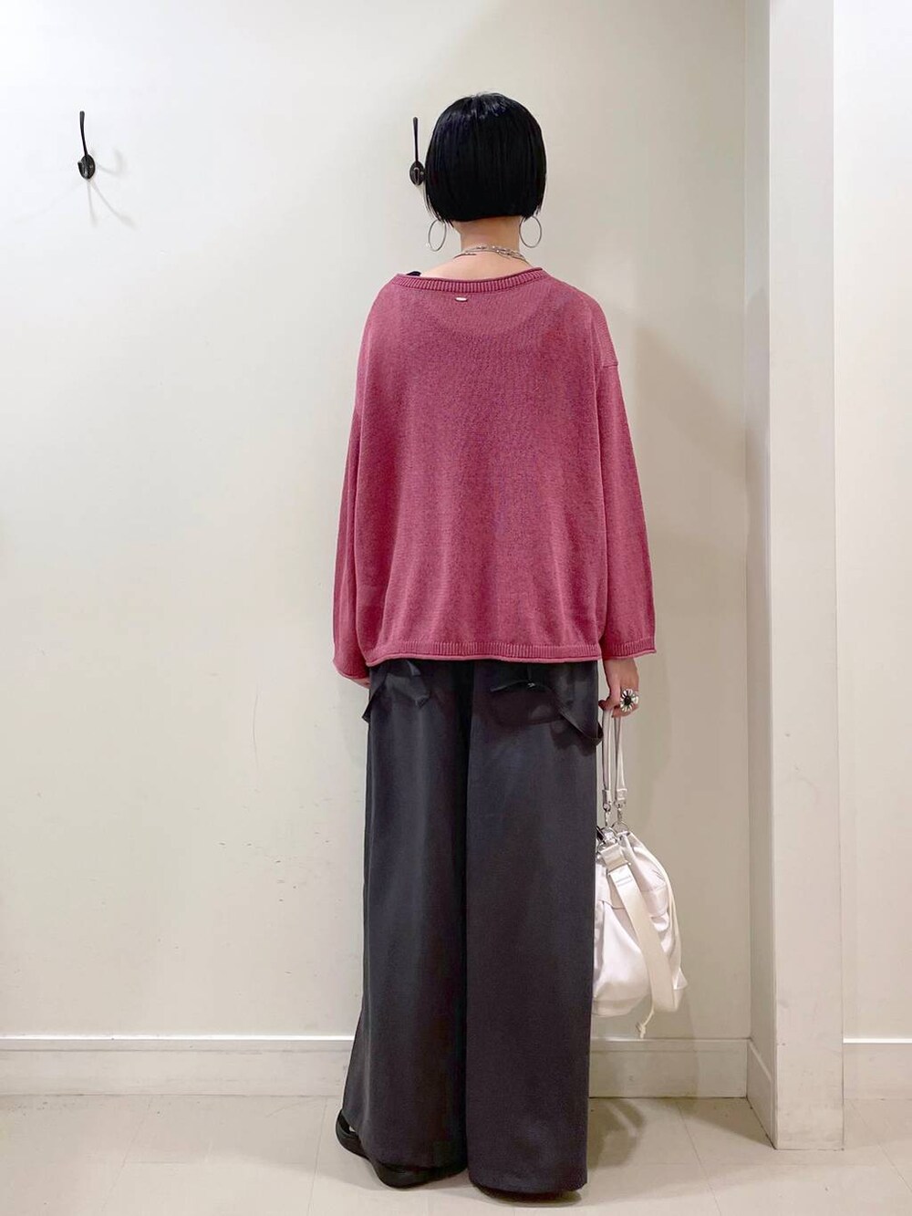 ホワイト系のショルダーバッグ、ブラック系のタンクトップ、ブラック系のサンダルを着用したレディースの秋コーディネートの4枚目の写真