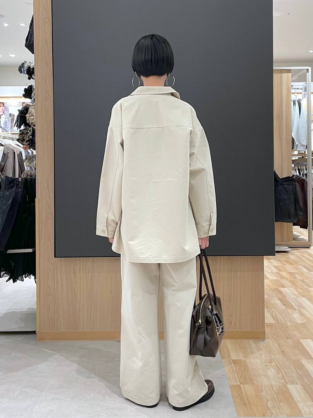 ブラウン系のローファー、ブラウン系のボストンバッグ、ベージュ系のニット/セーターを着用したレディースの春コーディネートの4枚目の写真