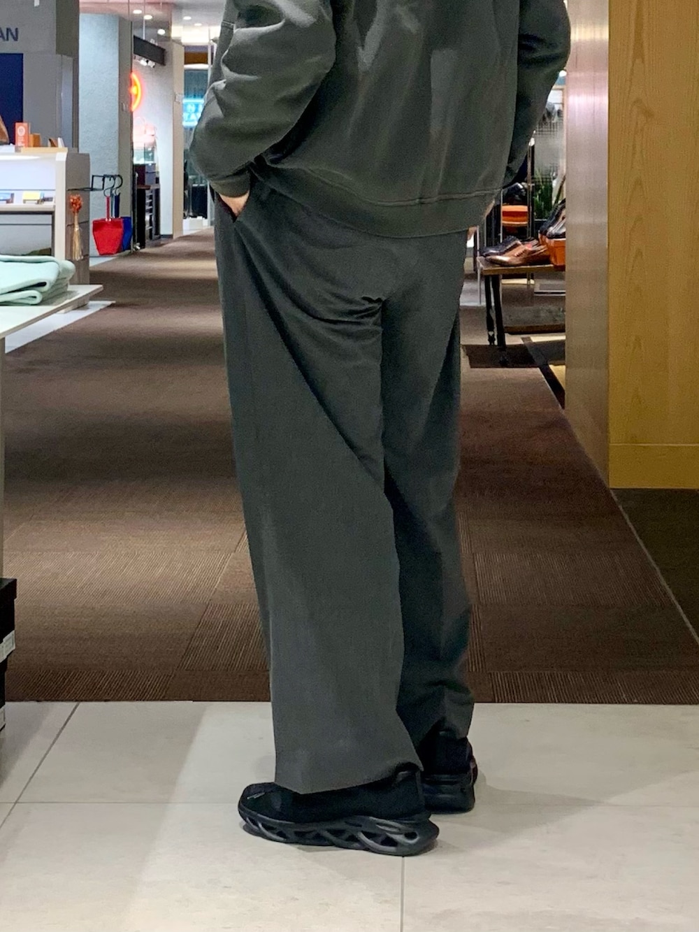 グレー系のパーカー、ホワイト系のTシャツ/カットソー、グレー系のスラックスを着用したメンズの春コーディネートの3枚目の写真