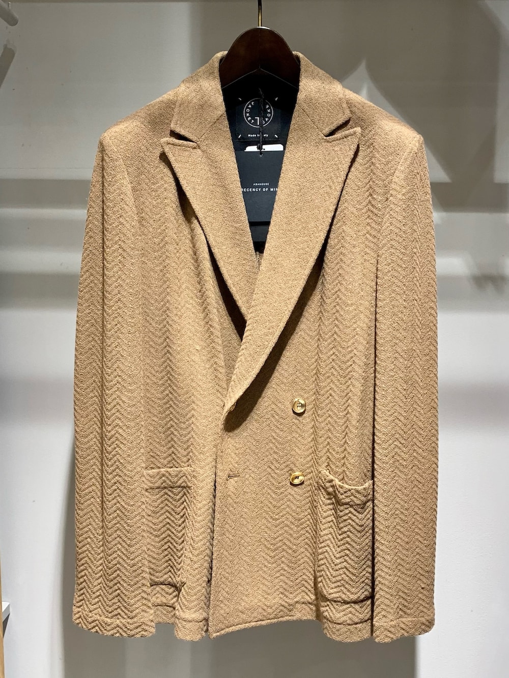 ブラウン系のテーラードジャケット、ホワイト系のシャツ/ブラウス、ブルー系のデニムパンツを着用したメンズの秋コーディネートの2枚目の写真