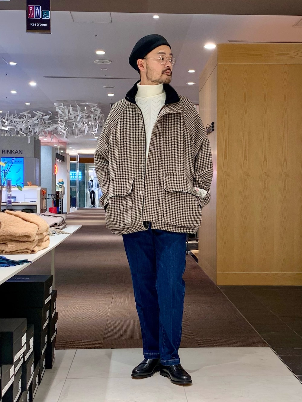 ホワイト系のニット/セーター、ベージュ系のステンカラーコート、ブルー系のデニムパンツを着用したメンズの冬コーディネートの3枚目の写真