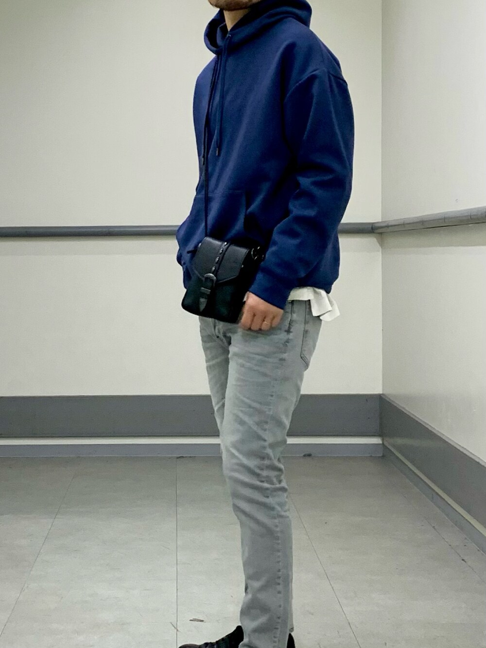ブルー系のパーカー、グレー系のデニムパンツを着用したメンズの春コーディネートの2枚目の写真