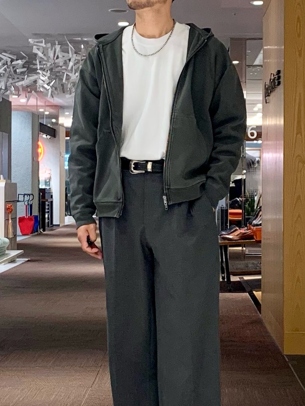 グレー系のパーカー、ホワイト系のTシャツ/カットソー、グレー系のスラックスを着用したメンズの春コーディネートの2枚目の写真