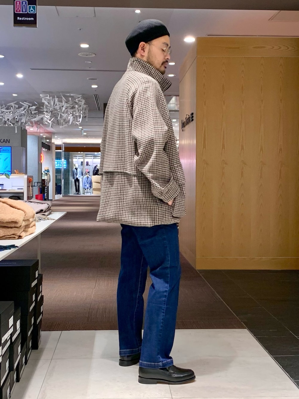 ホワイト系のニット/セーター、ベージュ系のステンカラーコート、ブルー系のデニムパンツを着用したメンズの冬コーディネートの4枚目の写真