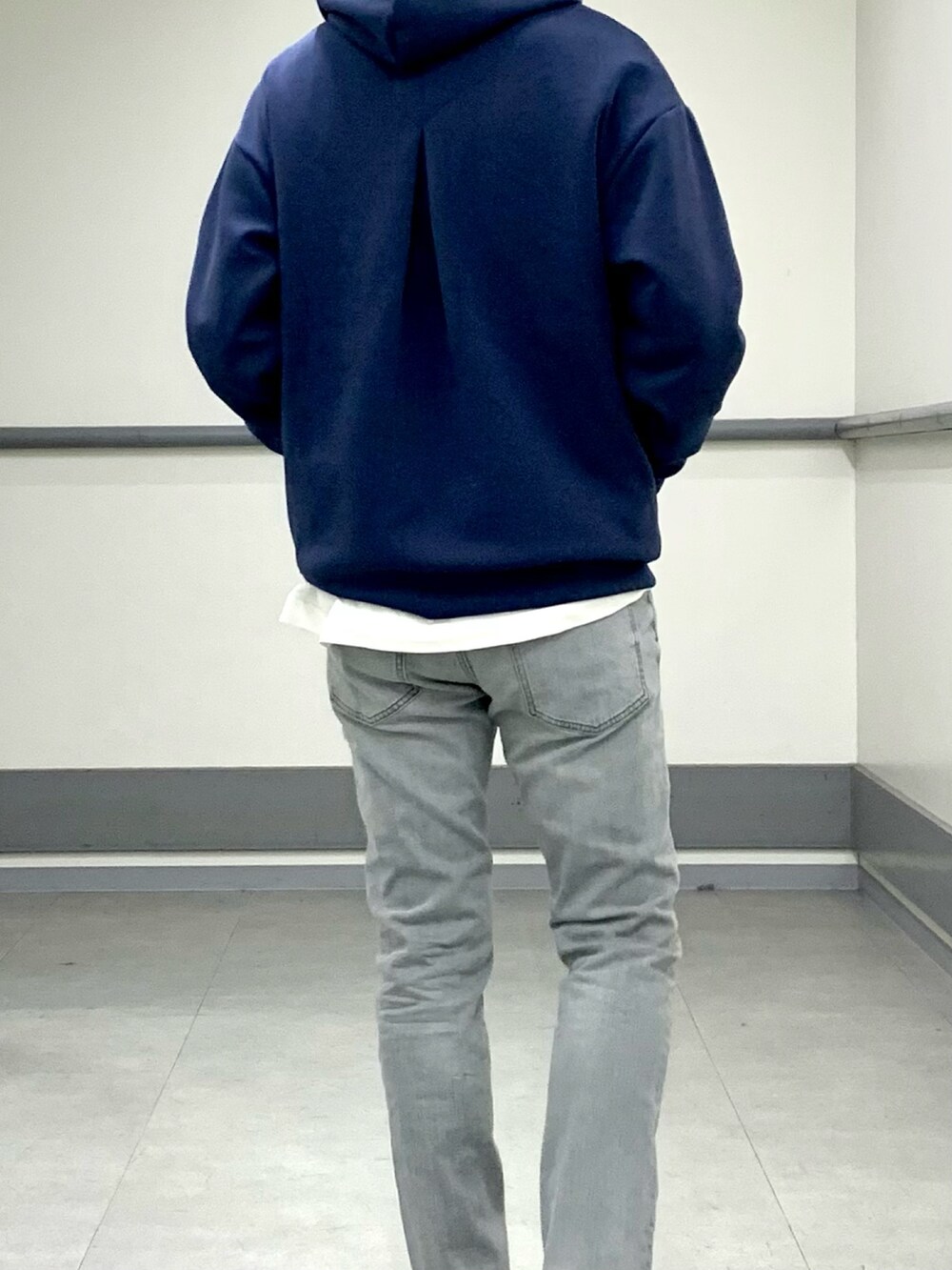 ブルー系のパーカー、グレー系のデニムパンツを着用したメンズの春コーディネートの3枚目の写真