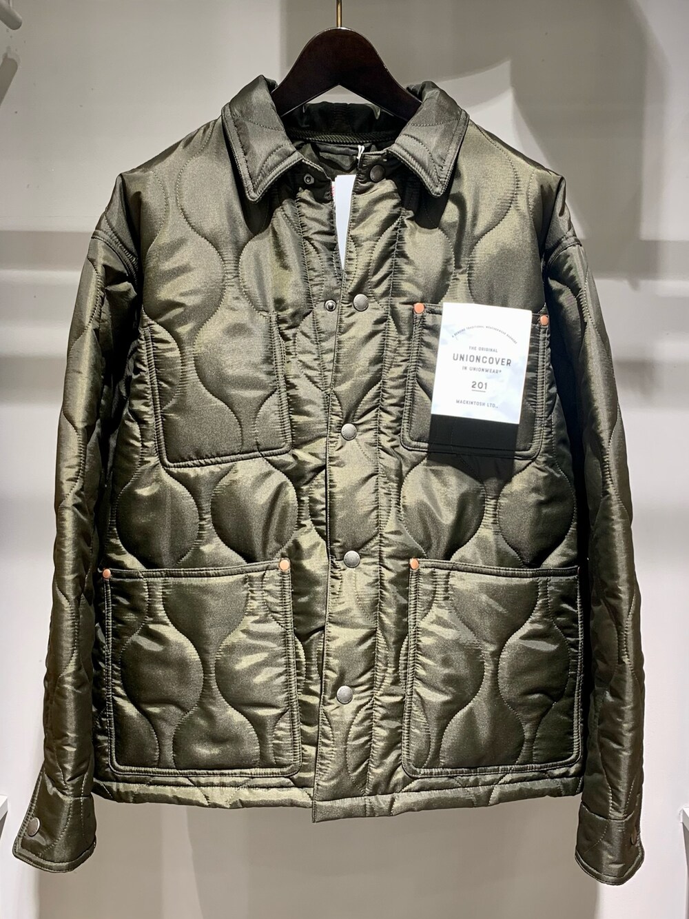 グリーン系のブルゾン、ブラック系のTシャツ/カットソー、グレー系のスラックスを着用したメンズの秋コーディネートの2枚目の写真