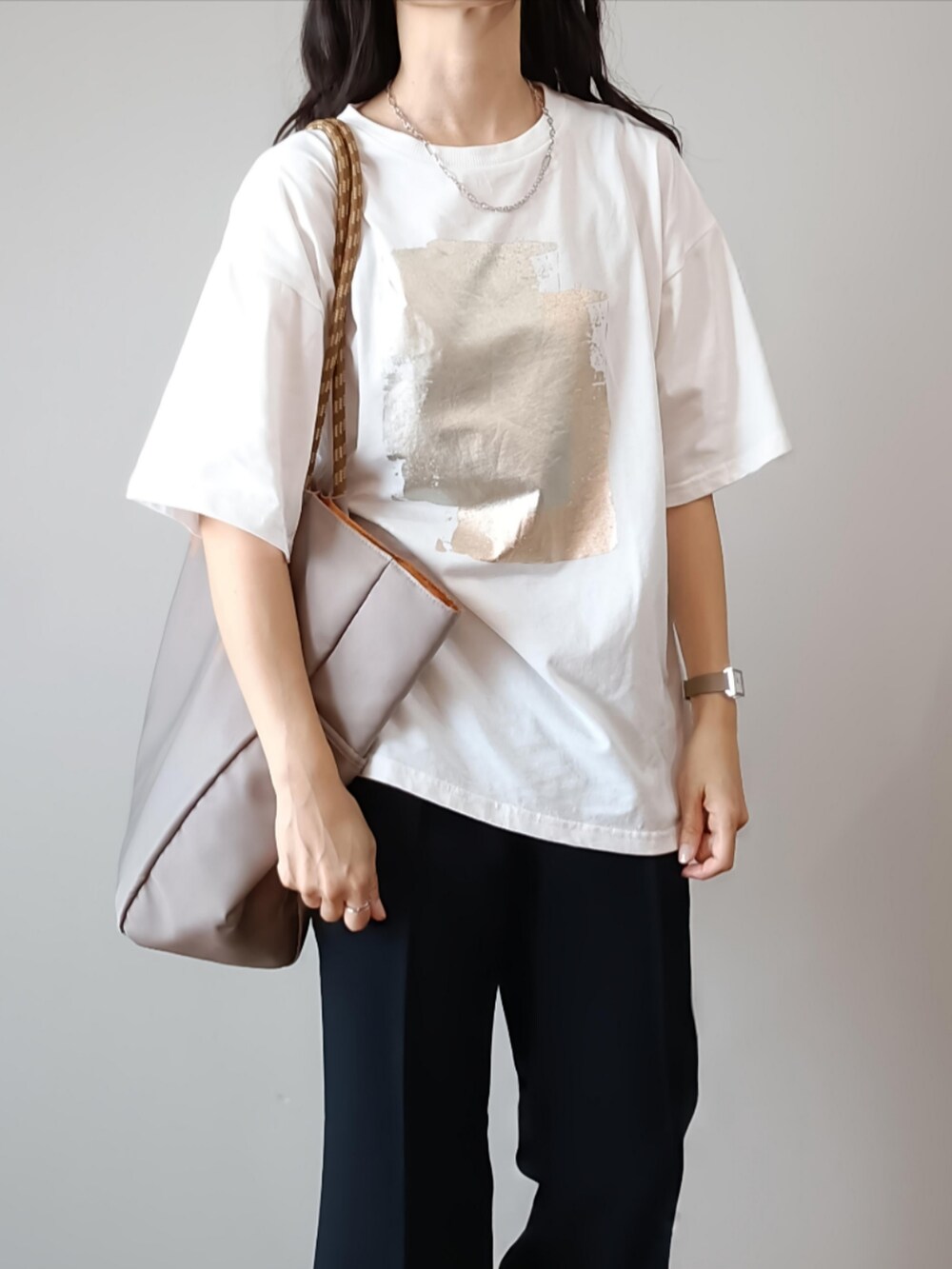 ホワイト系のTシャツ/カットソー、ブラック系のスラックス、グレー系のトートバッグを着用したレディースの夏コーディネートの3枚目の写真