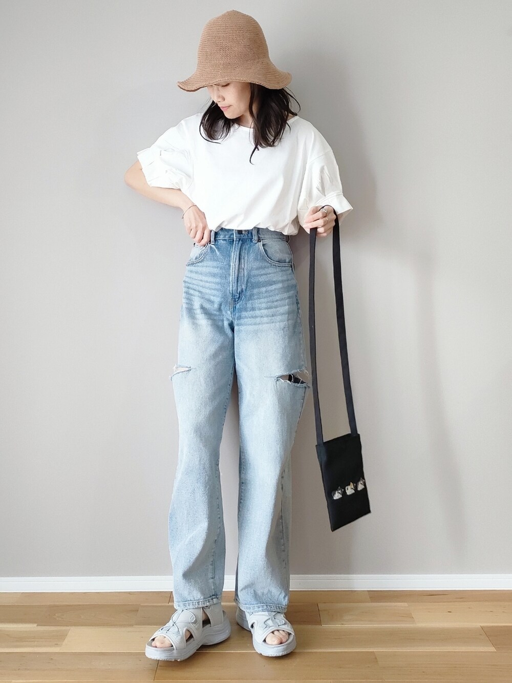 ホワイト系のTシャツ/カットソー、グレー系のサンダル、ブルー系のデニムパンツを着用したレディースの春コーディネートの3枚目の写真