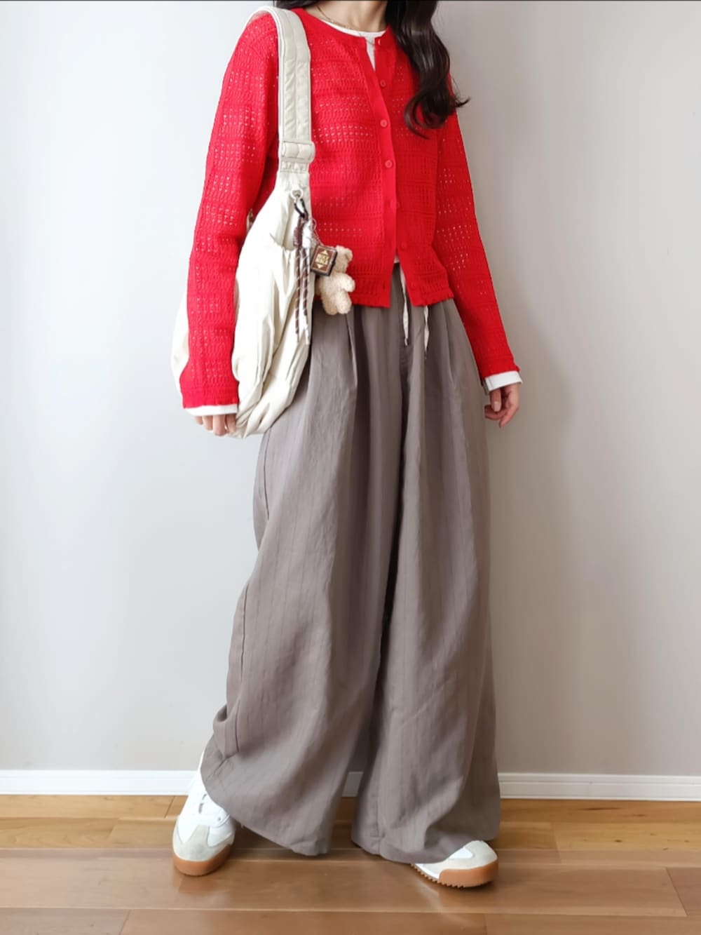 グレー系のその他パンツ、レッド系のカーディガン/ボレロ、ホワイト系のショルダーバッグを着用したレディースの春コーディネートの2枚目の写真