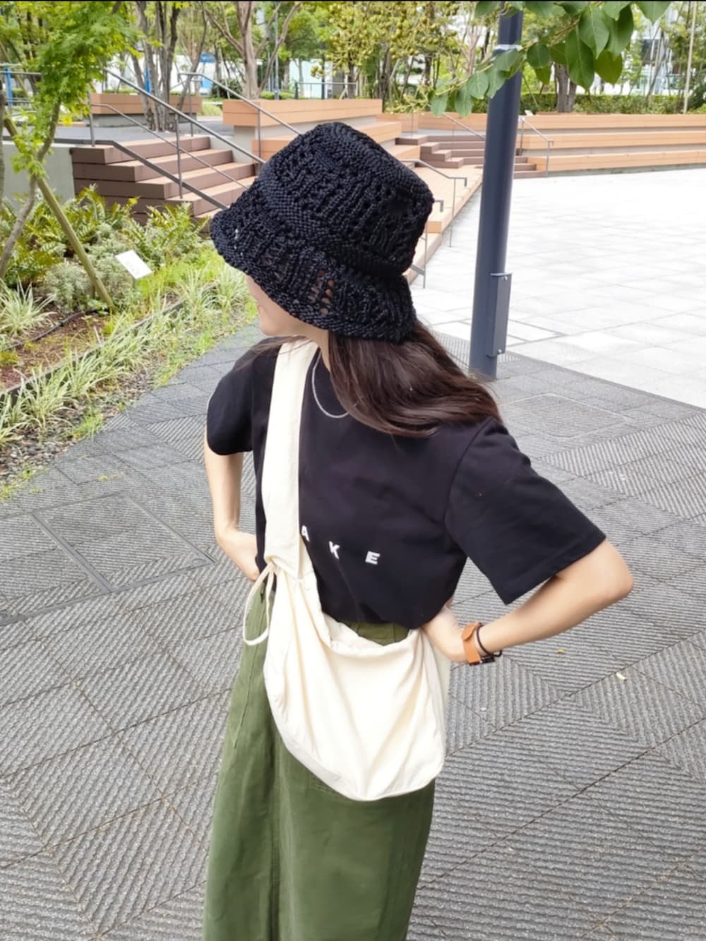 ベージュ系のスニーカー、ブラック系のTシャツ/カットソー、グリーン系のスカートを着用したレディースの秋コーディネートの3枚目の写真