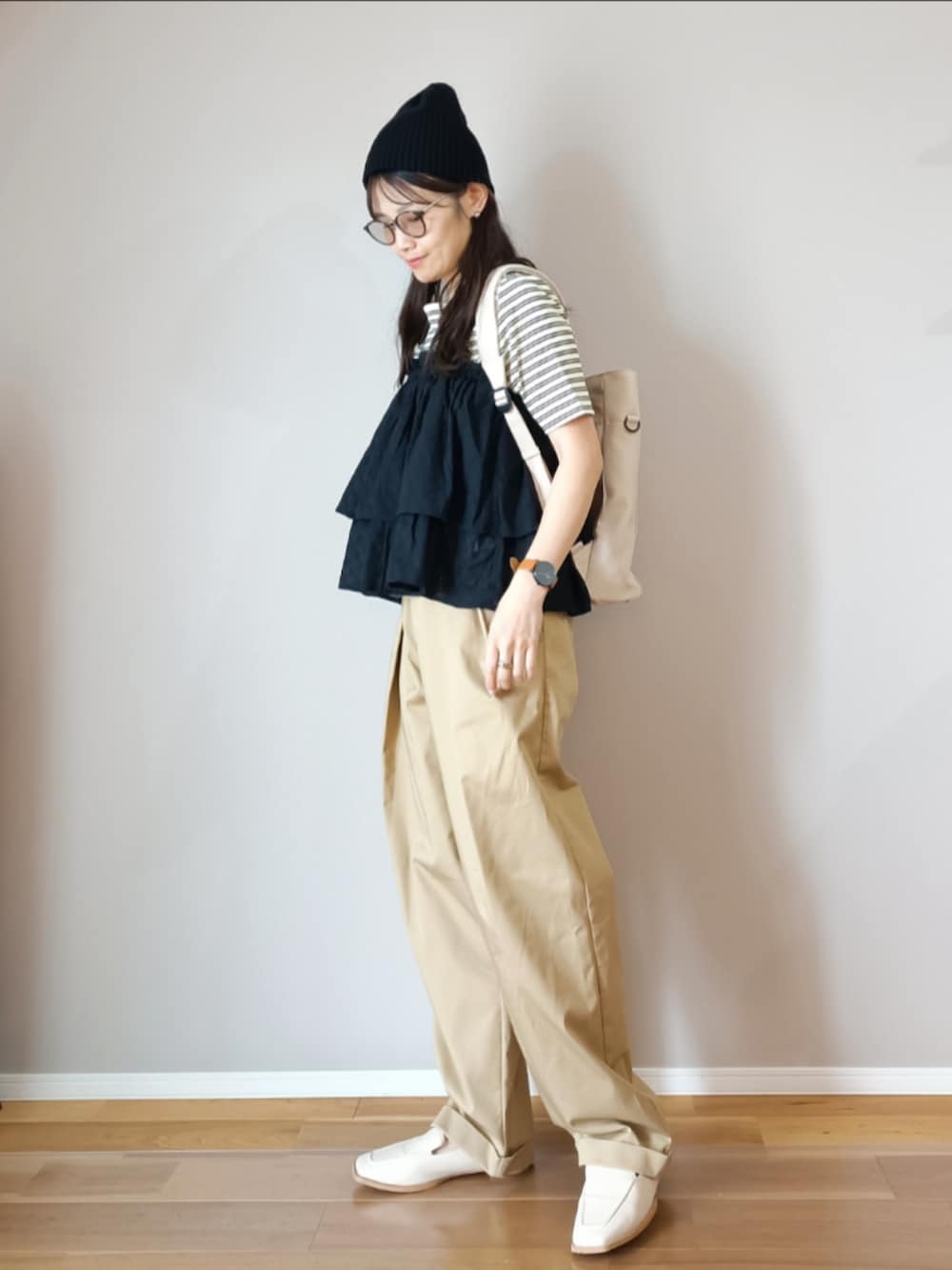 ブラック系のスカート、ホワイト系のTシャツ/カットソー、ベージュ系のチノパンツを着用したレディースの春コーディネートの2枚目の写真