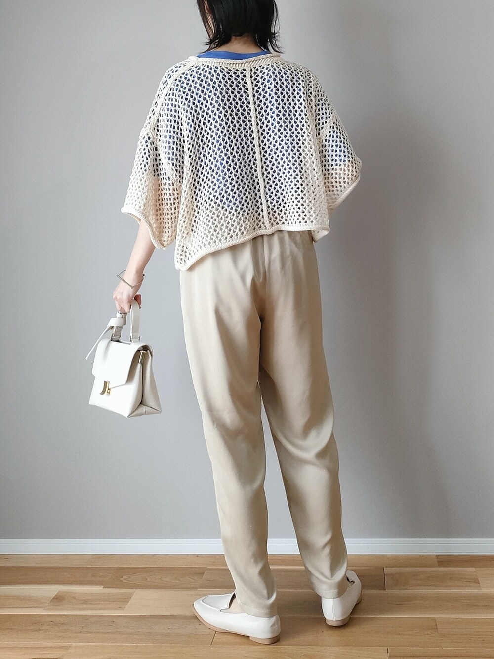 ホワイト系のニット/セーター、ブルー系のTシャツ/カットソー、ホワイト系のショルダーバッグを着用したレディースの春コーディネートの3枚目の写真