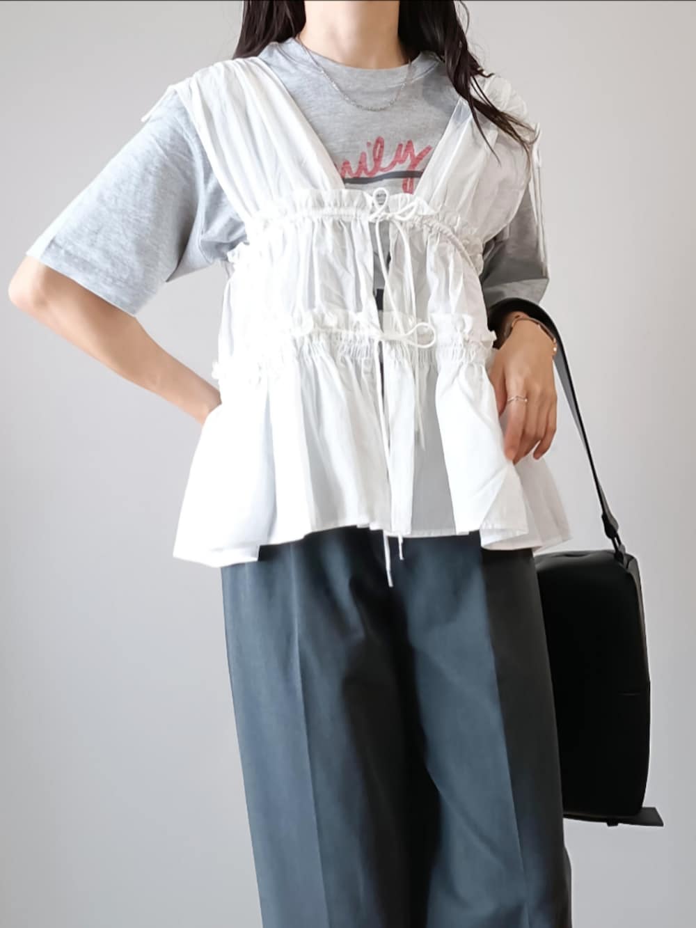 ホワイト系のシャツ/ブラウス、グレー系のTシャツ/カットソー、グレー系のパンツを着用したレディースの夏コーディネートの4枚目の写真