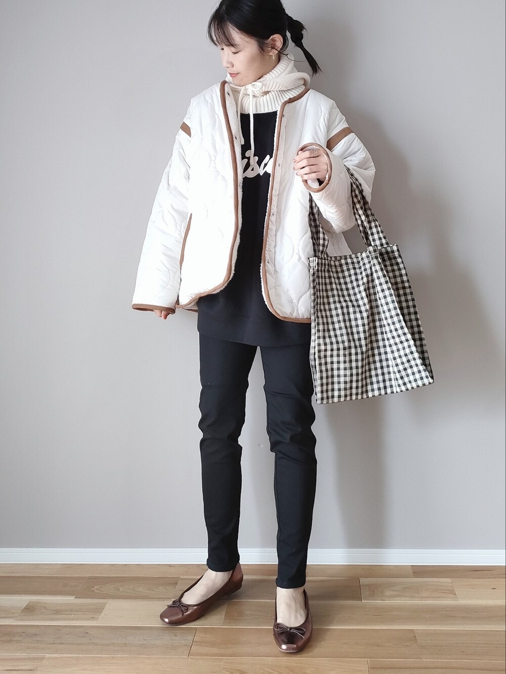 ホワイト系のブルゾン、ブラック系のデニムパンツ、ブラック系のスウェットを着用したレディースの秋コーディネートの3枚目の写真
