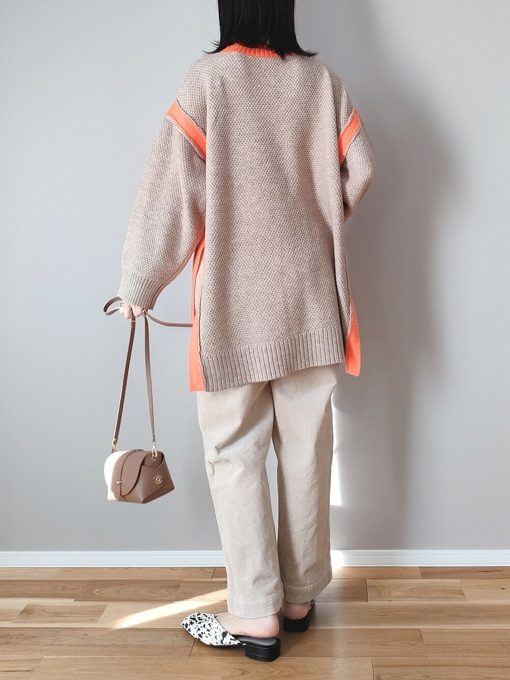 ベージュ系のニット/セーター、ホワイト系のサンダル、イエロー系のショルダーバッグを着用したレディースの冬コーディネートの4枚目の写真