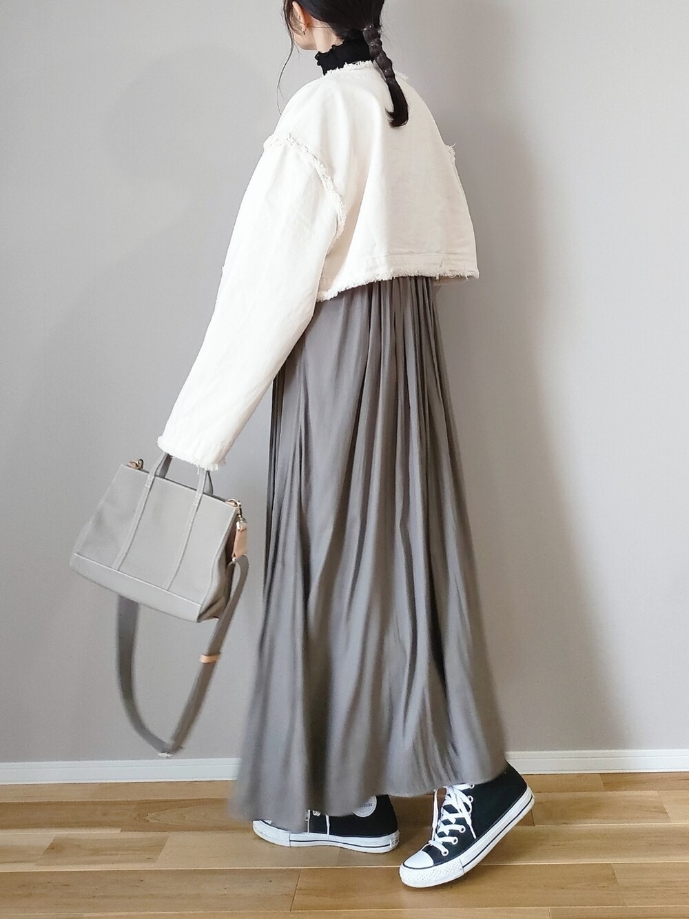 ホワイト系のデニムジャケット、グリーン系のスカート、グレー系のハンドバッグを着用したレディースの冬コーディネートの4枚目の写真