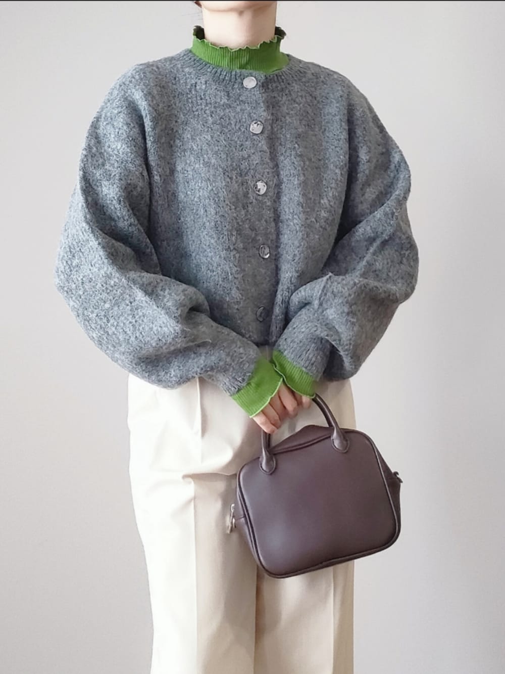 グレー系のカーディガン/ボレロ、グリーン系のTシャツ/カットソー、ブラウン系のボストンバッグを着用したレディースの秋コーディネートの3枚目の写真