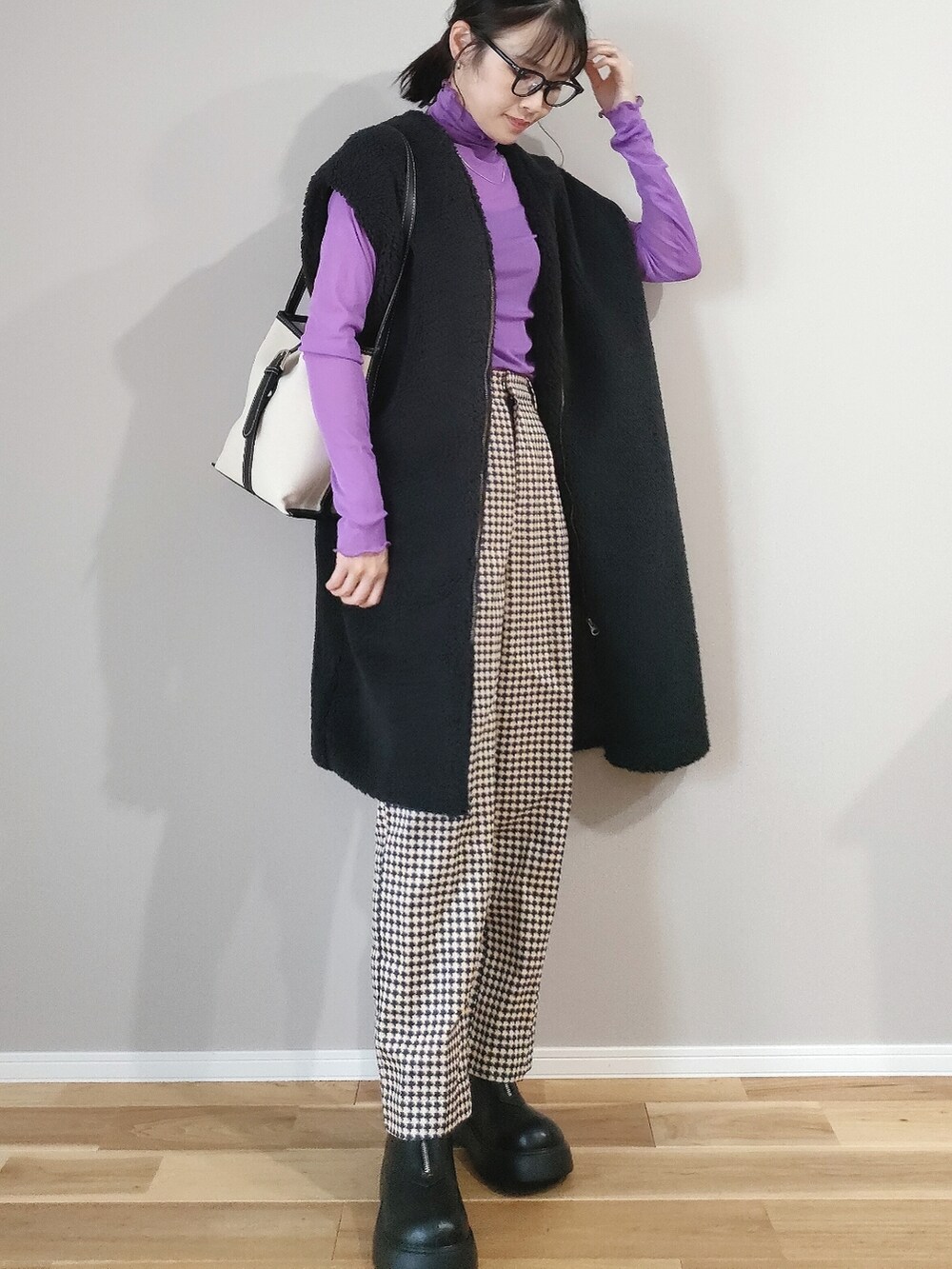 ブラック系のブーツ、ブラック系のベスト、パープル系のTシャツ/カットソーを着用したレディースの秋コーディネートの2枚目の写真