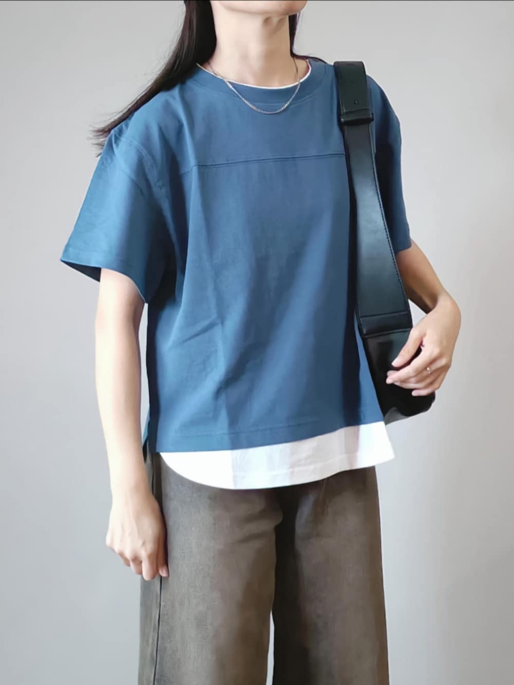 ブルー系のTシャツ/カットソー、ブラック系のデニムパンツ、ブラック系のショルダーバッグを着用したレディースの夏コーディネートの4枚目の写真