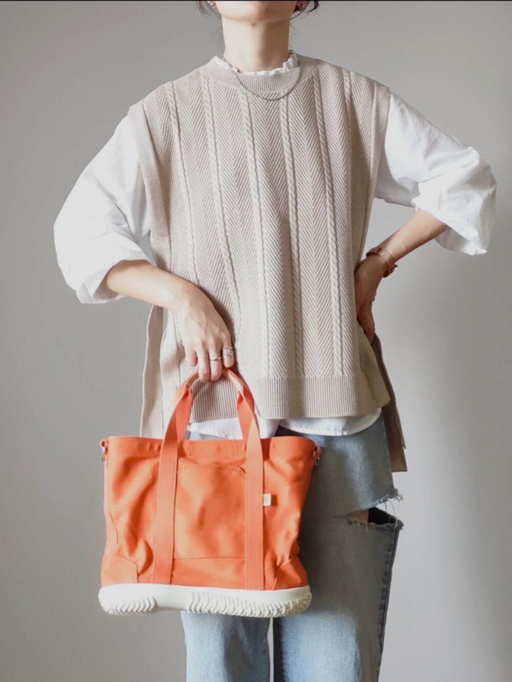 ベージュ系のベスト、ホワイト系のシャツ/ブラウス、ベージュ系のスニーカーを着用したレディースの秋コーディネートの3枚目の写真