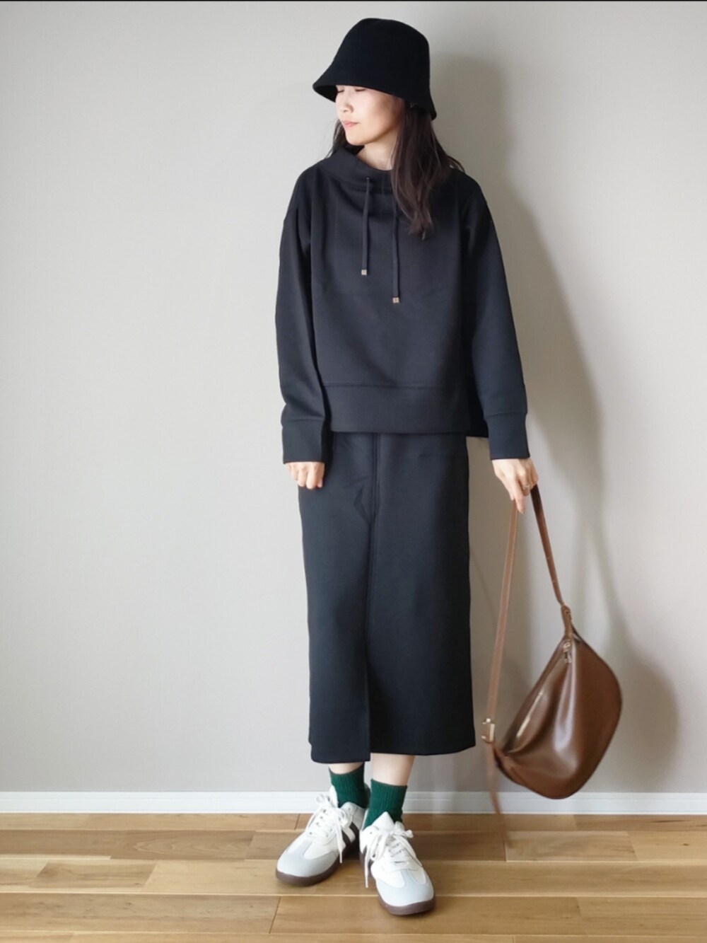 ベージュ系のスウェット、ブラック系のスウェット、ブラック系のスカートを着用したレディースの秋コーディネートの4枚目の写真