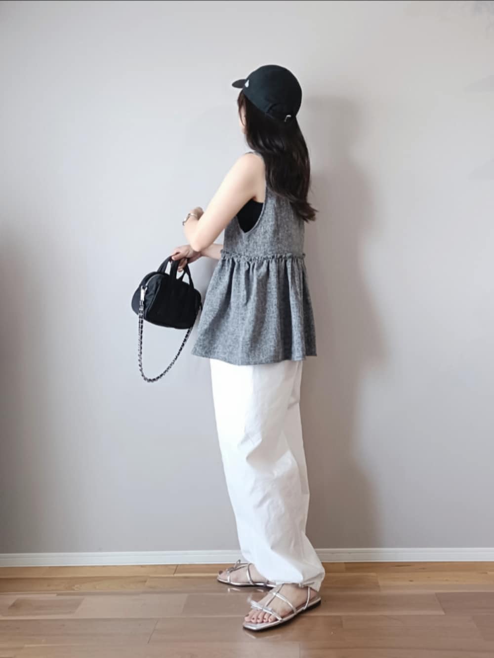 グレー系のベスト、ホワイト系のカーゴパンツ、ブラック系のキャップを着用したレディースの夏コーディネートの3枚目の写真