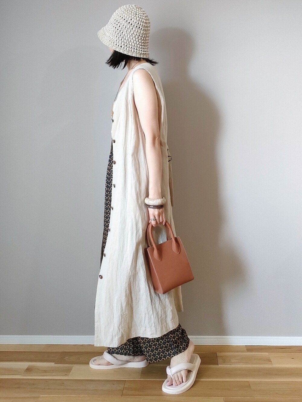 ホワイト系のキャミソール、ブルー系のその他パンツ、ブラウン系のショルダーバッグを着用したレディースの夏コーディネートの2枚目の写真