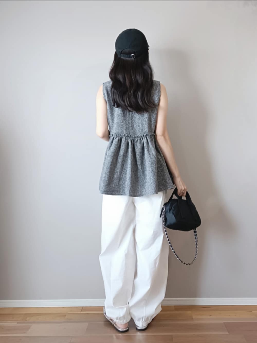 グレー系のベスト、ホワイト系のカーゴパンツ、ブラック系のキャップを着用したレディースの夏コーディネートの4枚目の写真