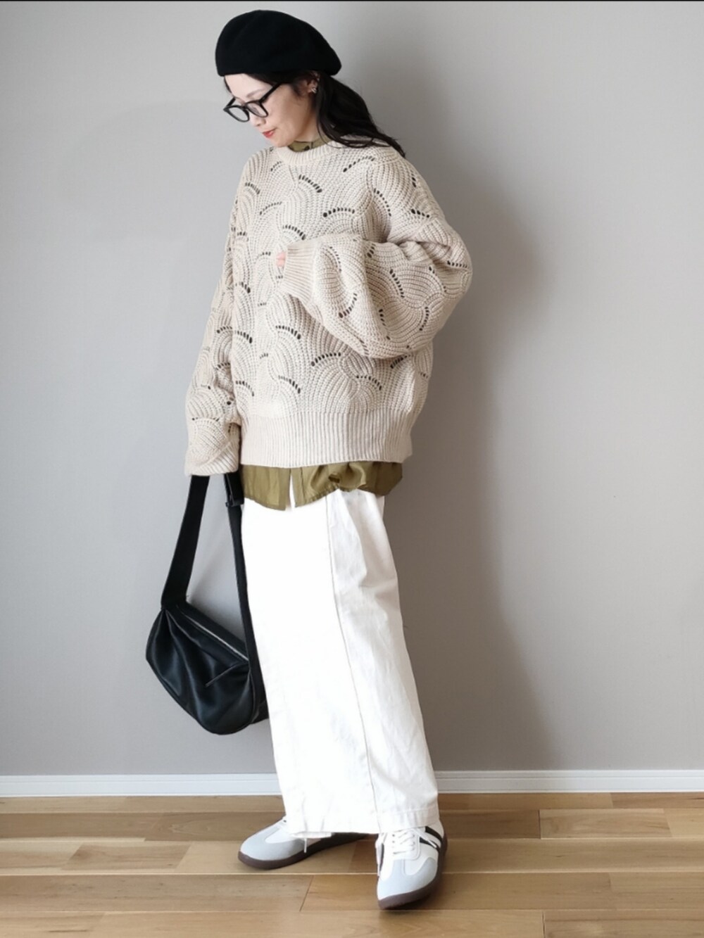 ホワイト系のニット/セーター、ブラック系のショルダーバッグ、グレー系のスニーカーを着用したレディースの秋コーディネートの3枚目の写真