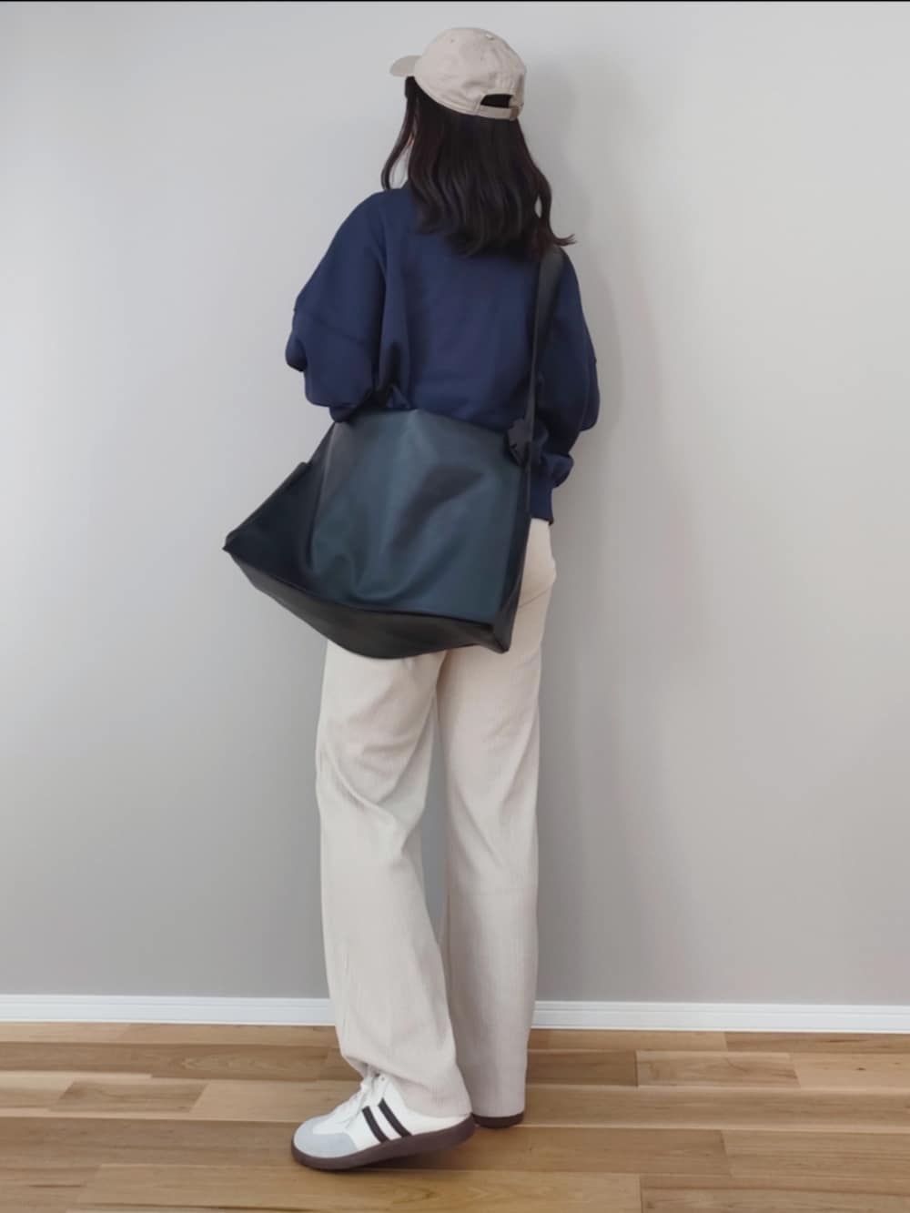 ブルー系のスウェット、ブラック系のショルダーバッグ、グレー系のスニーカーを着用したレディースの冬コーディネートの5枚目の写真