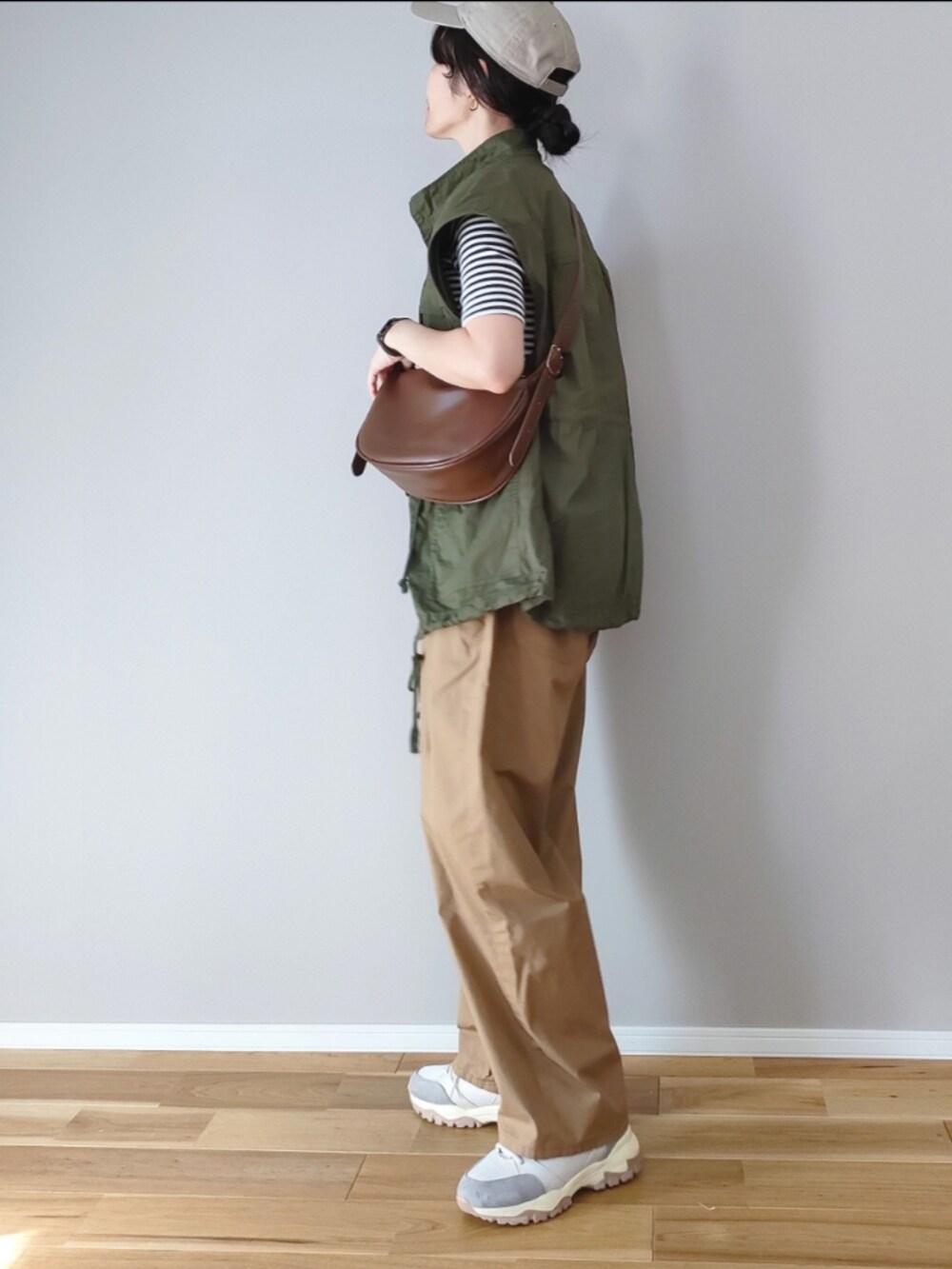 ブラウン系のショルダーバッグ、グリーン系のベスト、ベージュ系のその他パンツを着用したレディースの秋コーディネートの3枚目の写真