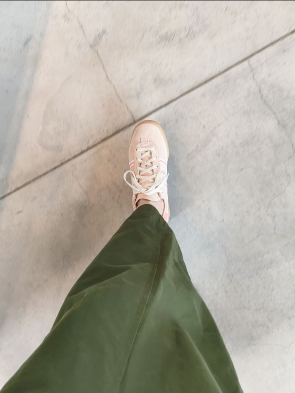 ベージュ系のスニーカー、ブラック系のTシャツ/カットソー、グリーン系のスカートを着用したレディースの秋コーディネートの4枚目の写真