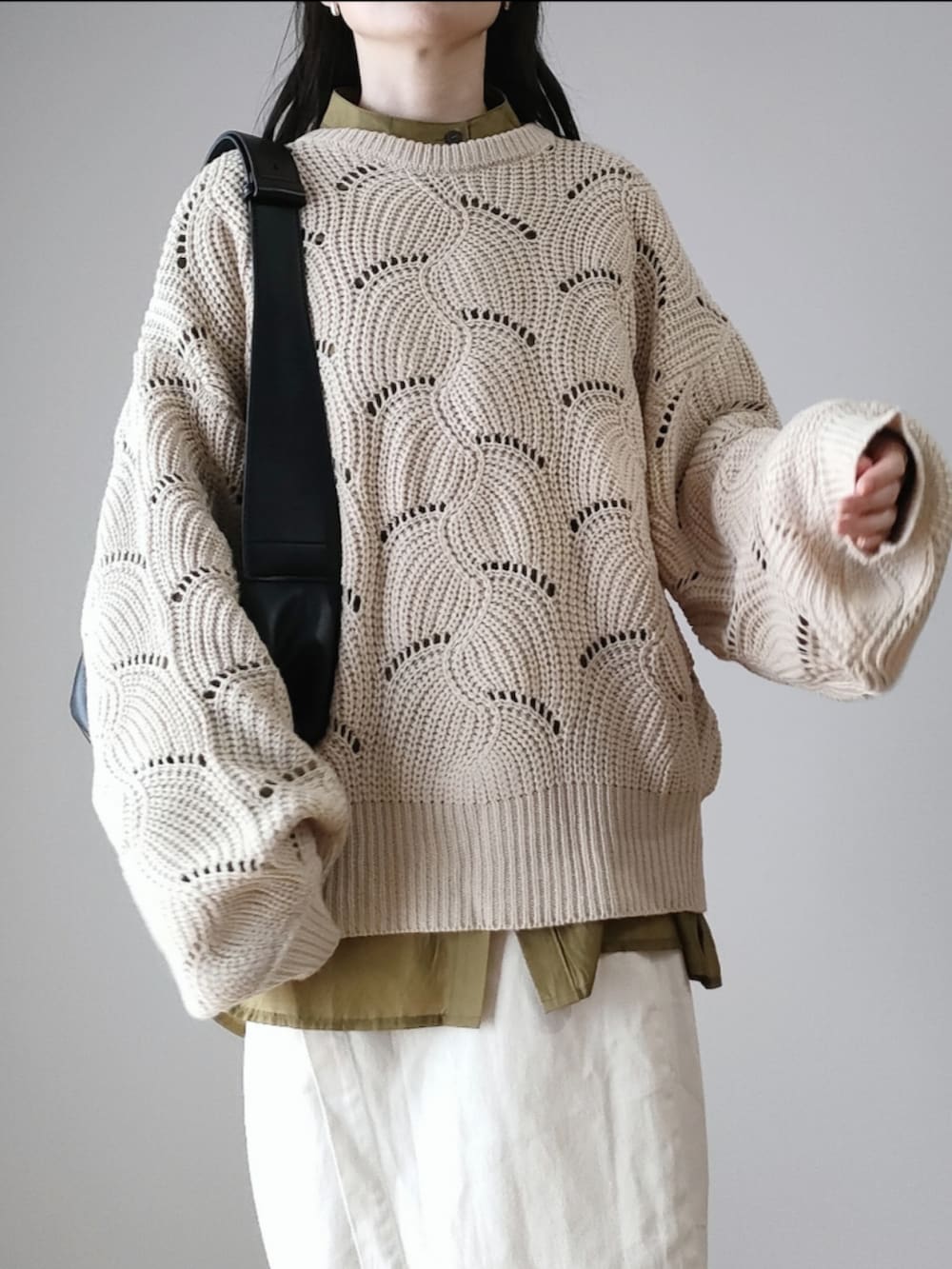 ホワイト系のニット/セーター、ブラック系のショルダーバッグ、グレー系のスニーカーを着用したレディースの秋コーディネートの2枚目の写真