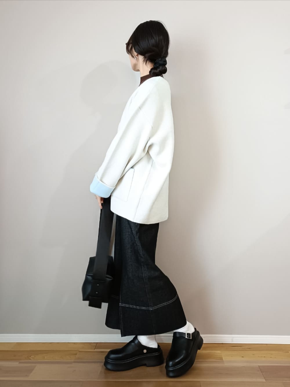 ホワイト系のカーディガン/ボレロ、ブラック系のスカート、ブラック系のスリッポンを着用したレディースの冬コーディネートの3枚目の写真