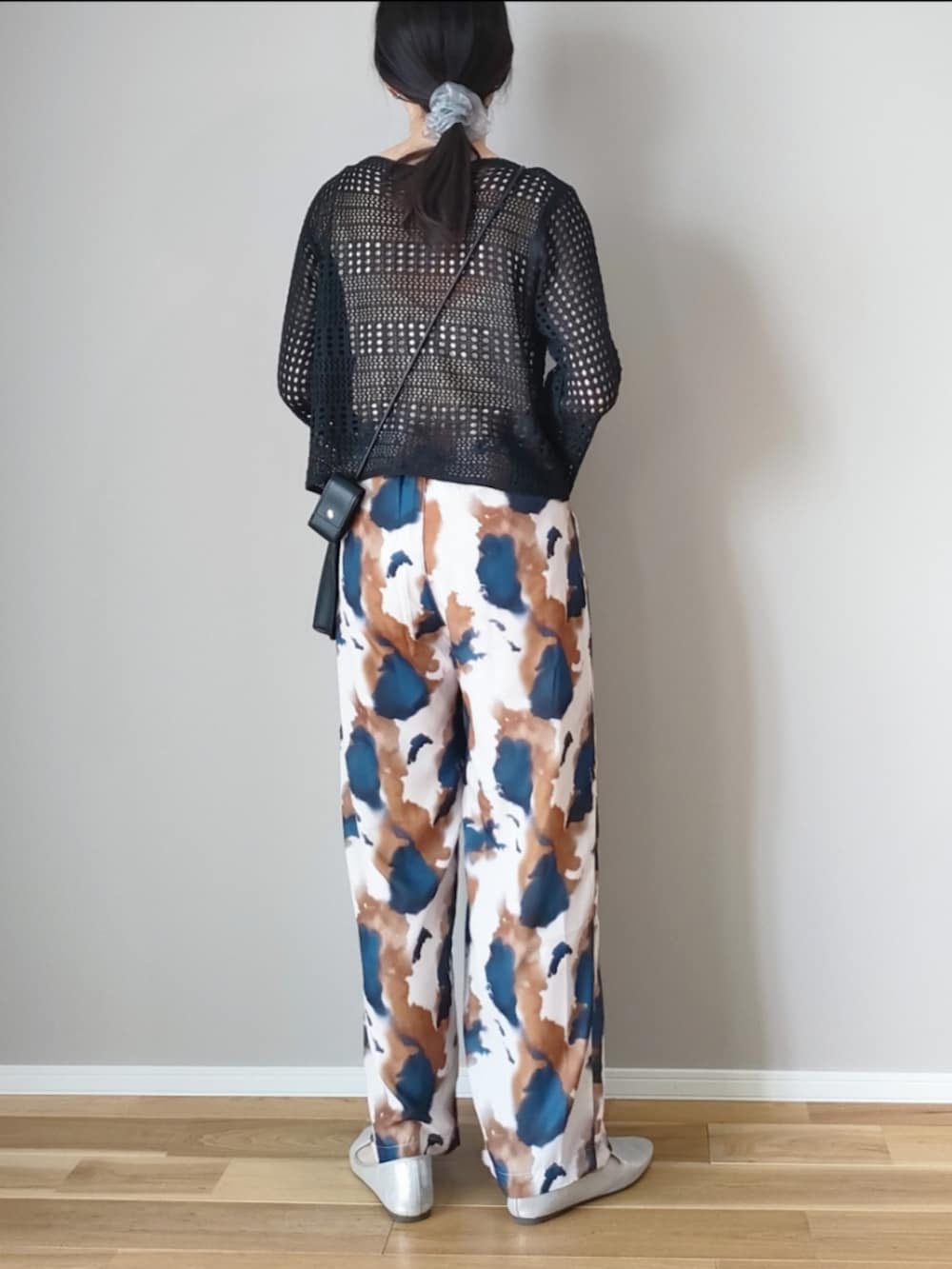 ブラック系のニット/セーター、ブラウン系のその他パンツ、ブラック系のショルダーバッグを着用したレディースの春コーディネートの4枚目の写真