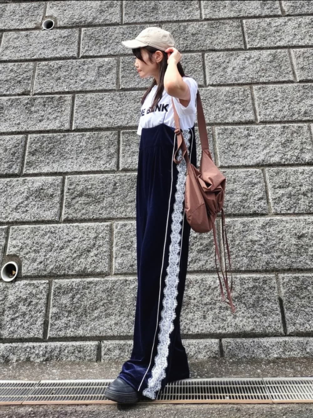 ブルー系のサロペット/オーバーオール、ホワイト系のTシャツ/カットソー、ブラック系のスニーカーを着用したレディースの秋コーディネートの3枚目の写真