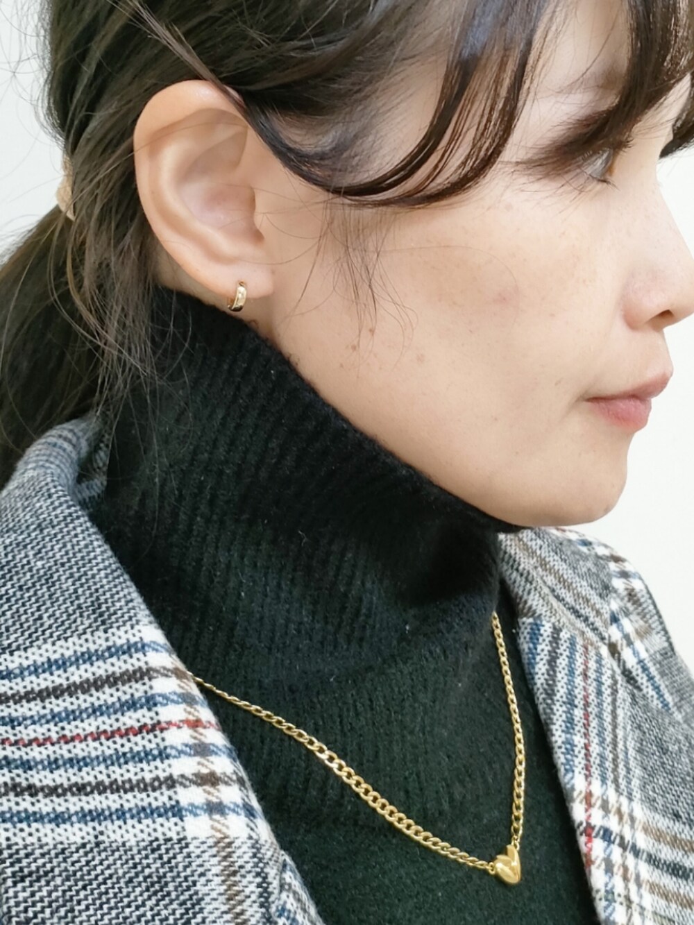 グレー系のチェスターコート、ブラウン系のトートバッグ、ブラック系のワンピースを着用したレディースの冬コーディネートの3枚目の写真