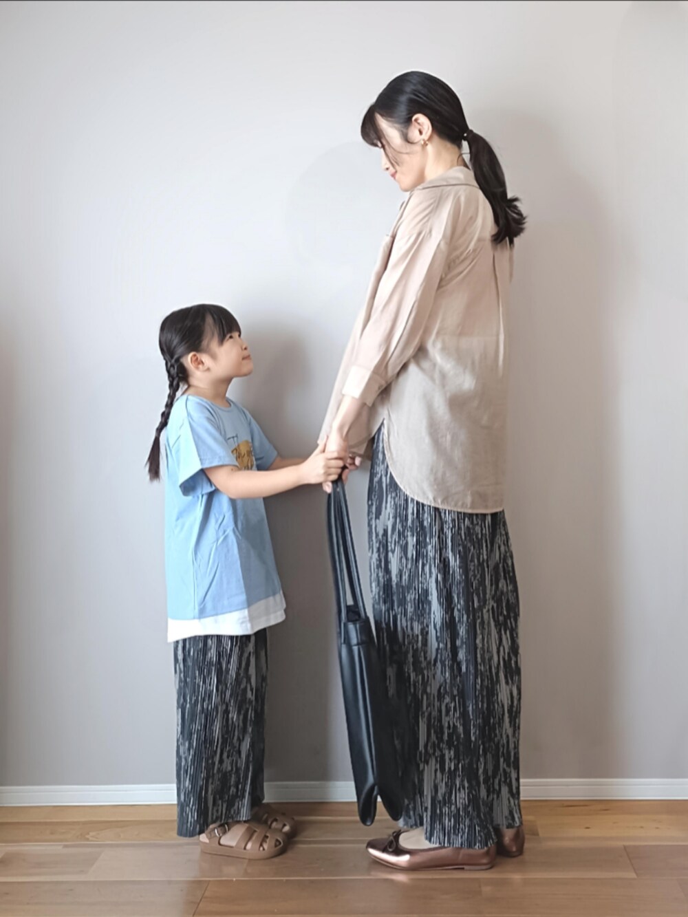 ブルー系のTシャツ/カットソー、ブラック系のトートバッグ、ベージュ系のシャツ/ブラウスを着用したレディースの夏コーディネートの2枚目の写真