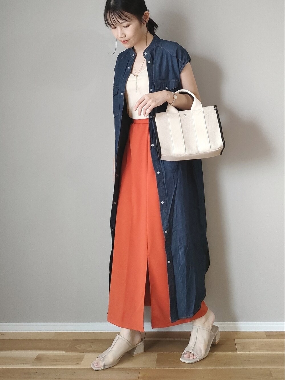 オレンジ系のスカート、ホワイト系のキャミソール、ブルー系のワンピースを着用したレディースの夏コーディネートの2枚目の写真