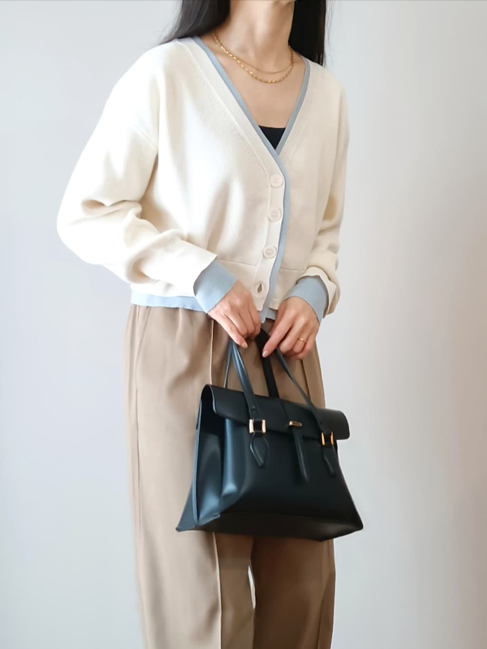 ホワイト系のカーディガン/ボレロ、ベージュ系のスニーカー、ブラック系のハンドバッグを着用したレディースの春コーディネートの2枚目の写真