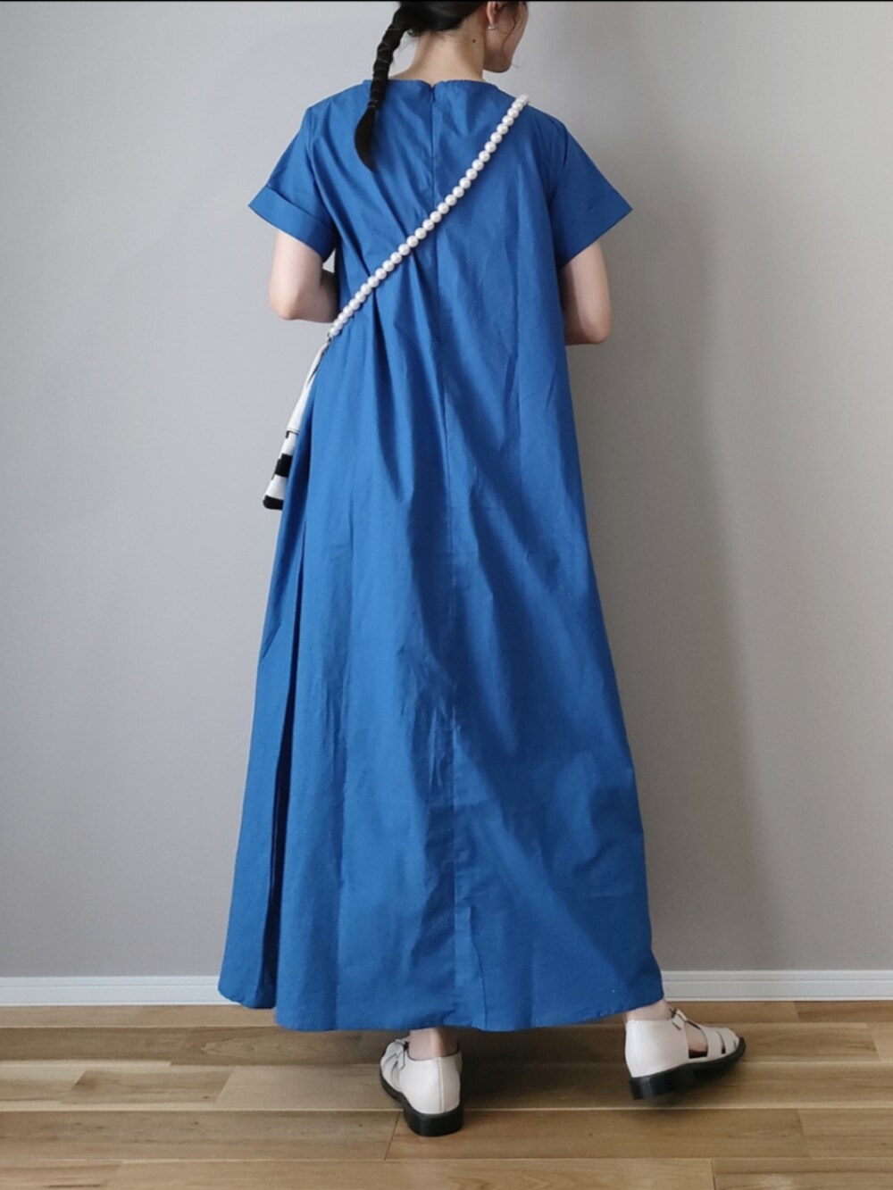 ブルー系のワンピース、ホワイト系のショルダーバッグ、ホワイト系のサンダルを着用したレディースの夏コーディネートの4枚目の写真